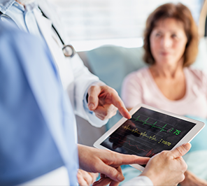Doctor pointing at tablet ECG while patient watches