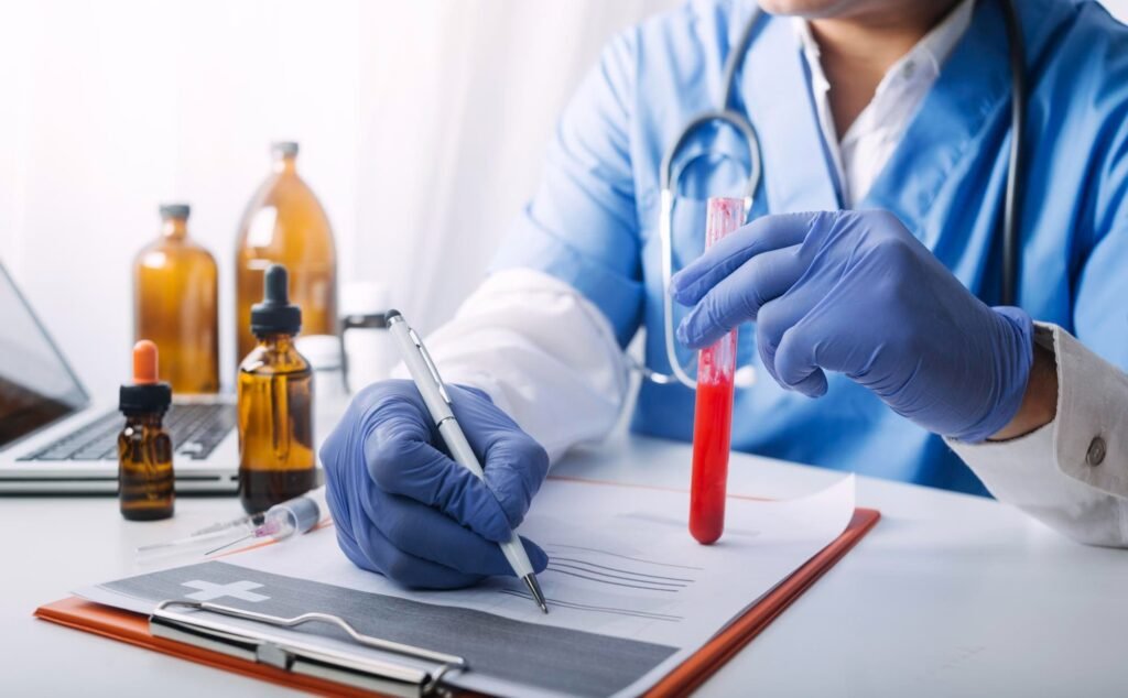 A gloved medical professional holds a blood sample vial and pen while documenting results