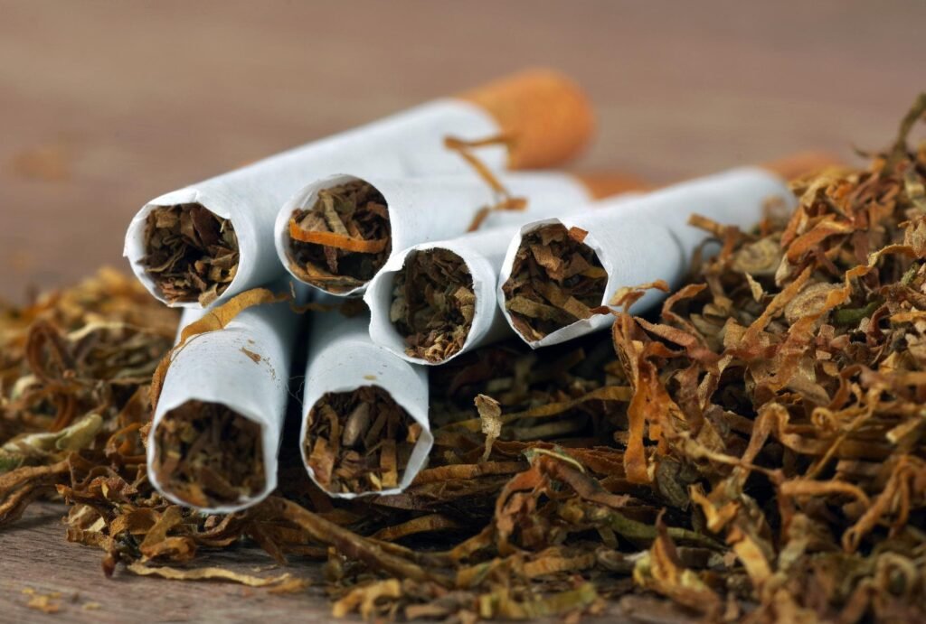 Cigarettes and loose tobacco on wooden surface