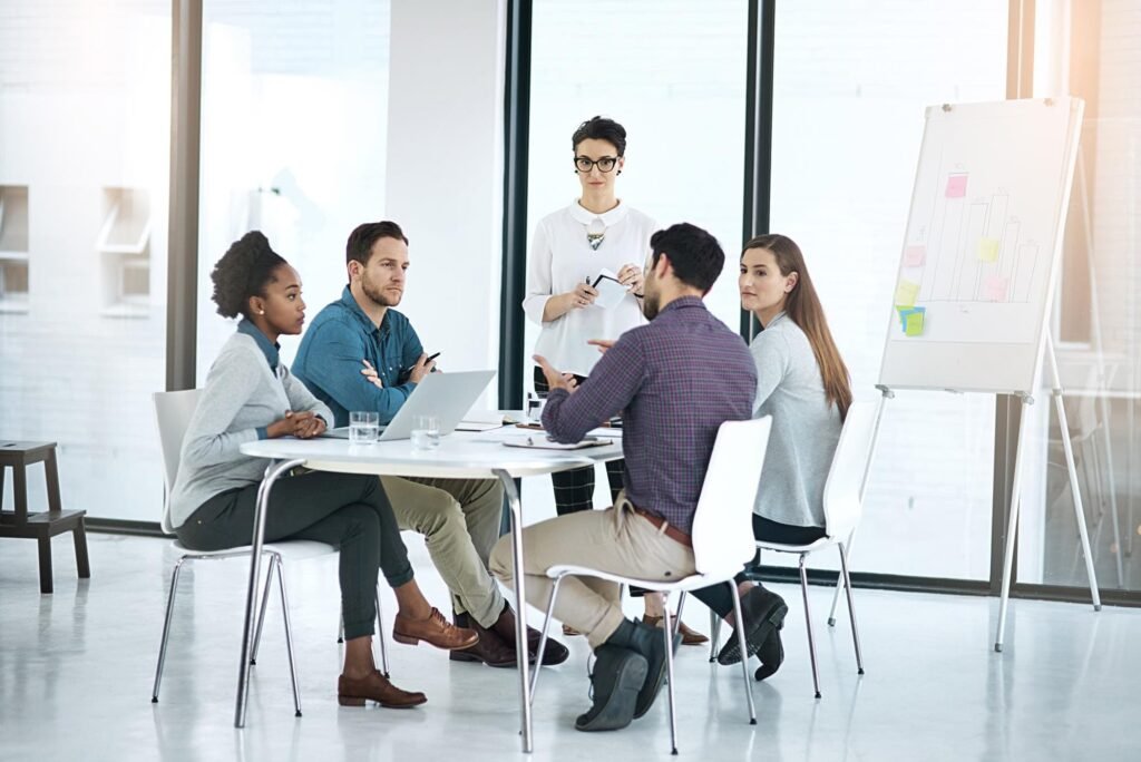 A group of five professionals collaborate around a table in a bright office,