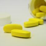 Yellow oblong pills spilling from bottle