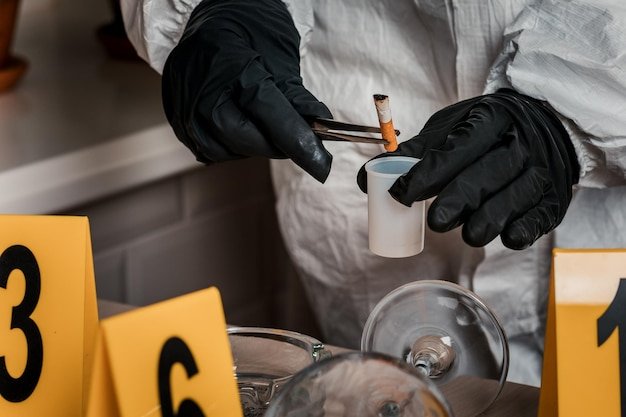 Forensic investigator collecting cigarette butt evidence
