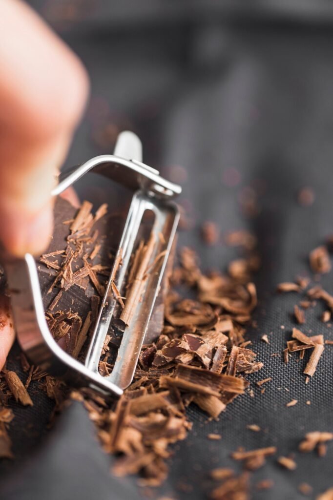Hand shaving dark chocolate into fine curls