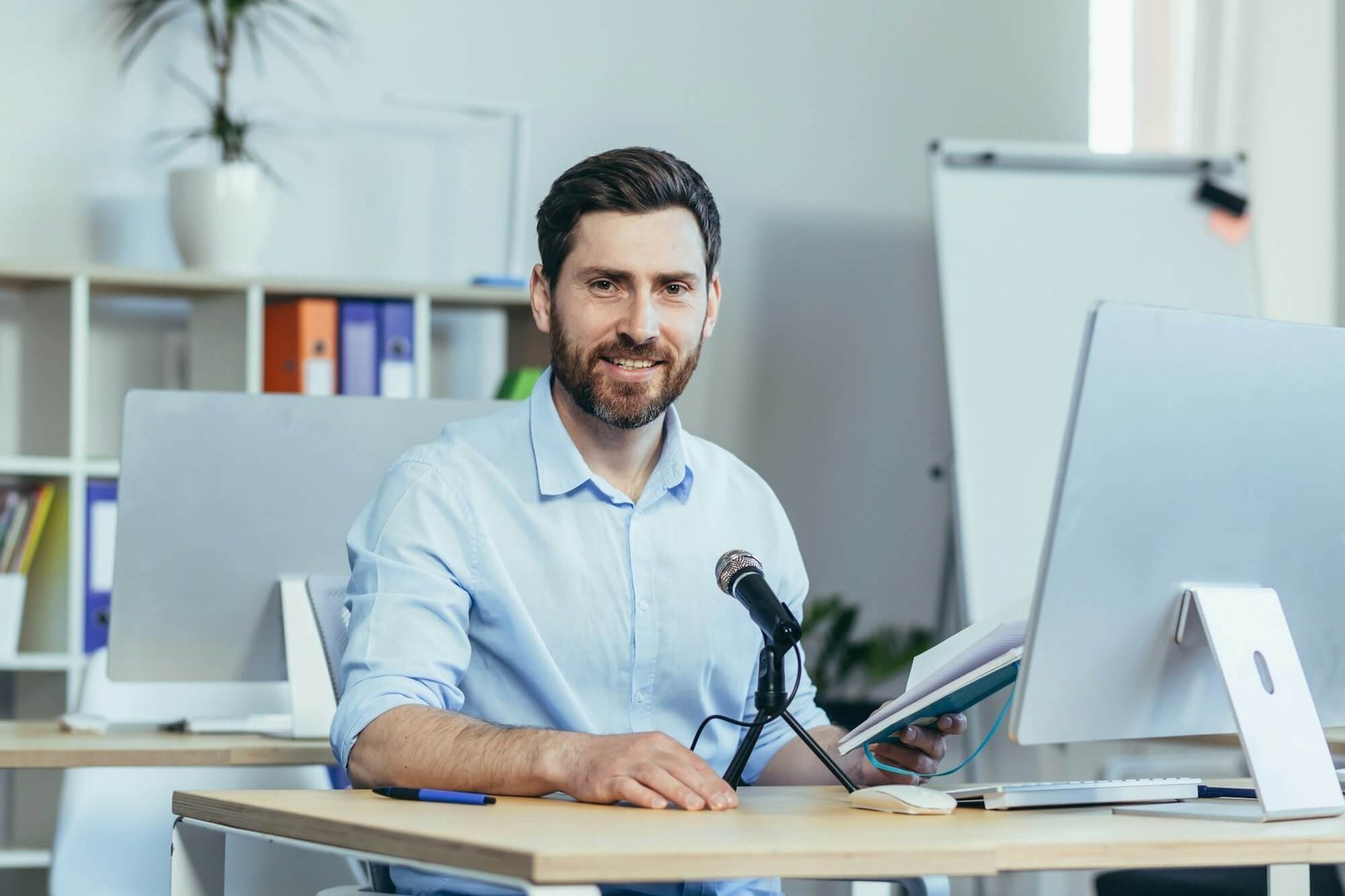 Man recording podcast at desk with computer
