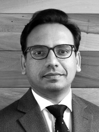 Headshot of man in suit and glasses