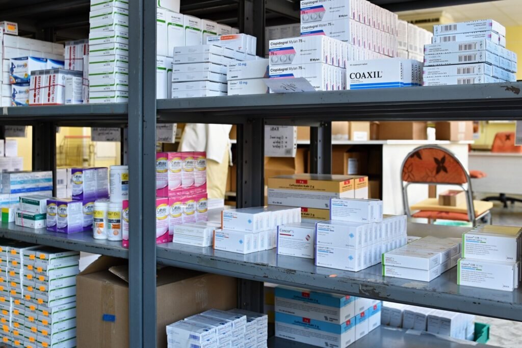 Metal shelves stocked with various boxes of medication.