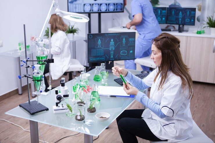 Scientist examining green liquid in laboratory