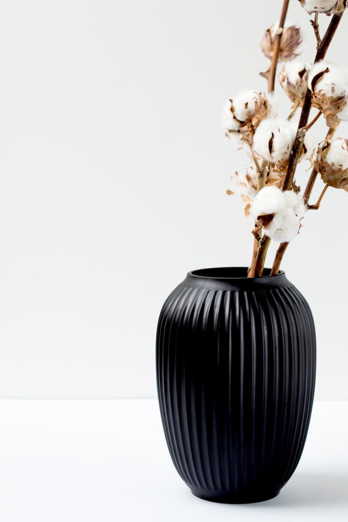 Black ribbed vase with cotton stems